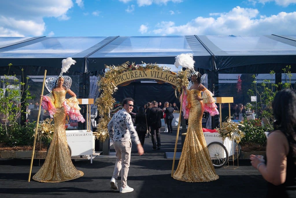 Indianapolis chef walking into a clear tent next to stilt walkers for a food photography shoot